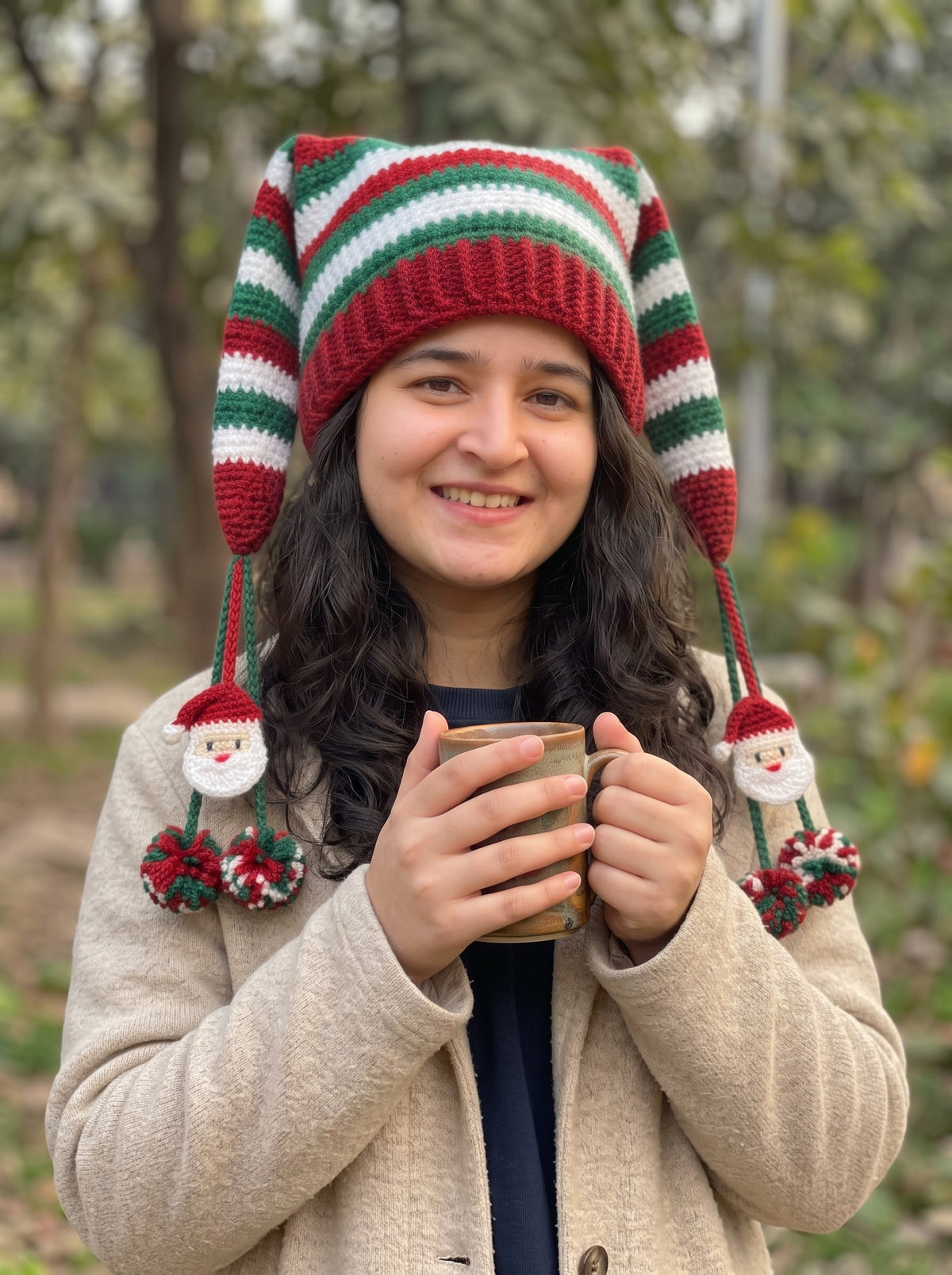 Girl wearing handmade crochet Christmas elf hat with red green white stripes and Santa pom-poms outdoors