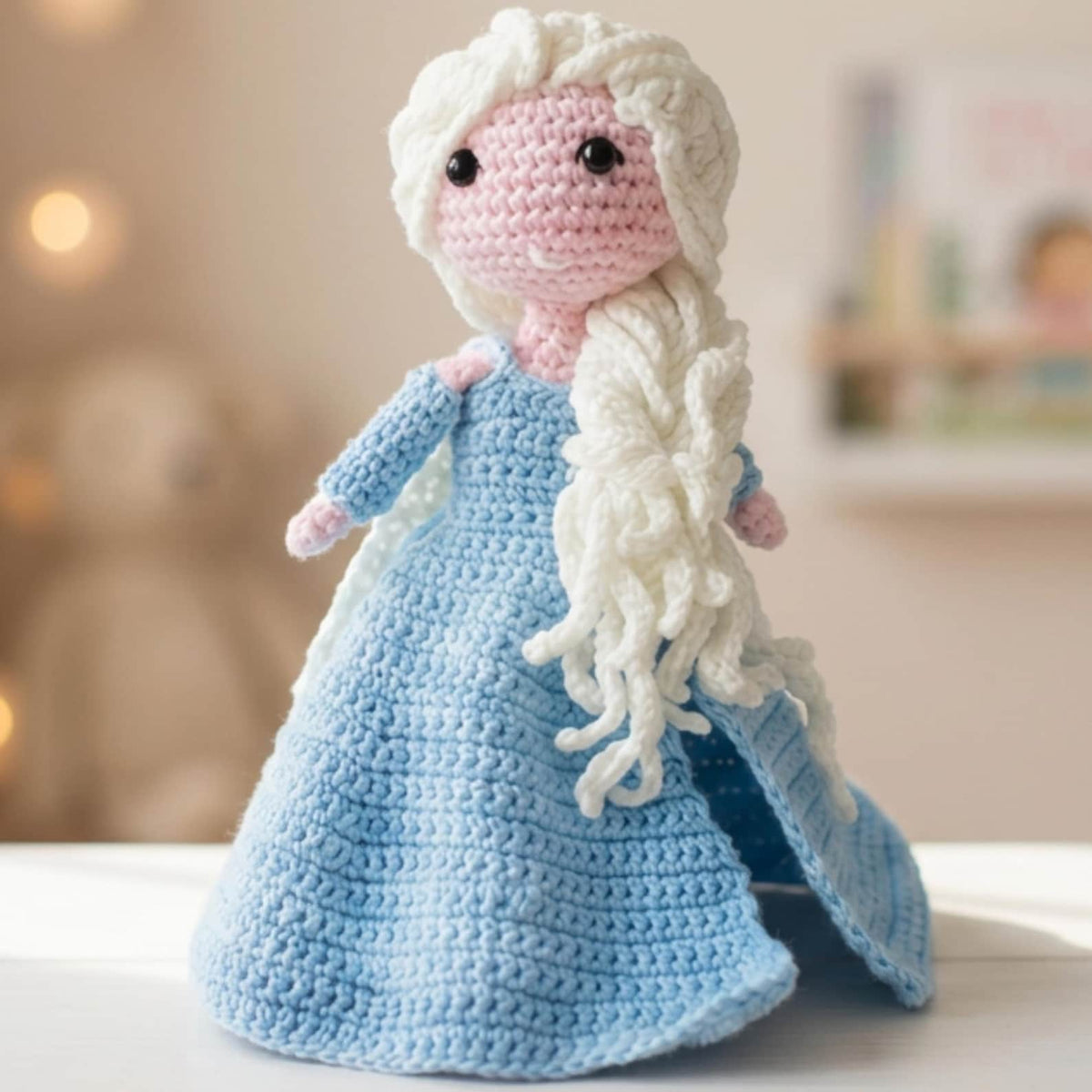 Crochet snow princess amigurumi doll front view with blue dress and flowing hair